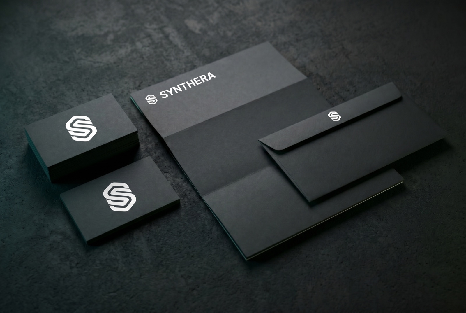 Synthera stationery flat-lay — cards, letterhead, envelope